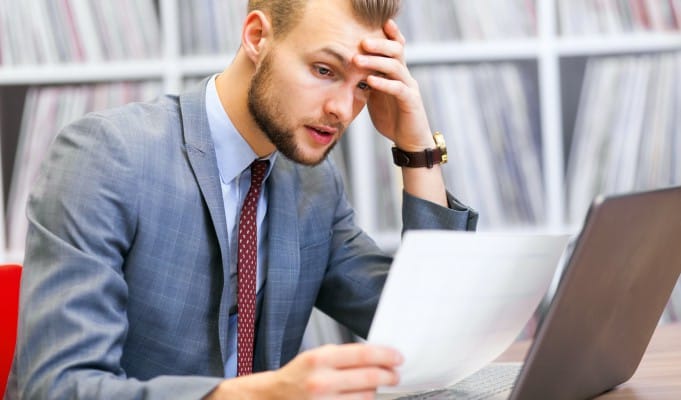 Kontroler sprawdza prawidłowość dokumentacji projektowej porównując treść dokumentów papierowych z danymi elektronicznymi na swoim laptopie.