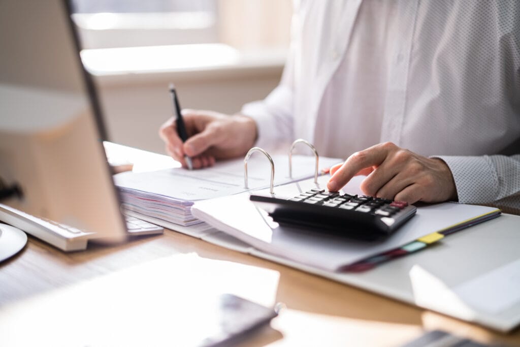 Osoba siedząca przy biurku, przed komputerem, rozliczająca projekt w systemie CST2021